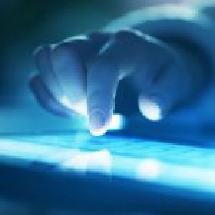 CustomerCareMC_Industries_InformationTechnology Right Hand on Laptop Lit Up in Dark Room